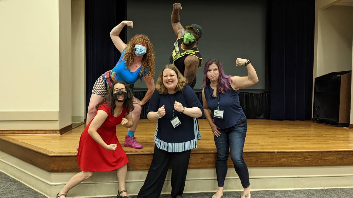 A group of people flexing the arms in a cirle