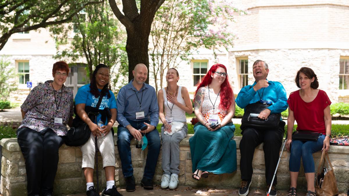 A group of AccessU attendees sitting outside laughing