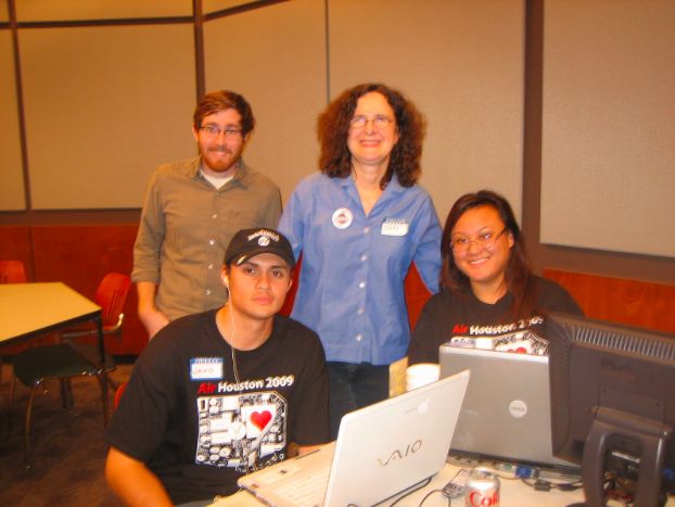 Four individuals at AIR Houston 2009, posing for a photograph. Two people are standing while the other two are seated. All four are wearing smiles, looking at the camera with a sense of camaraderie and enjoyment.