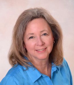 smiling woman with blond hair and light blue shirt